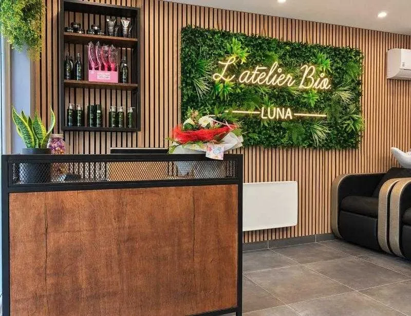 Accueil du salon en bois brut, bardage et mur végétal
